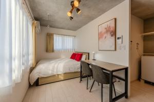 a bedroom with a bed and a table with chairs at Ferio Kamata in Tokyo