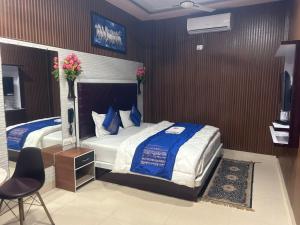 a bedroom with a large bed with blue and white sheets at Hotel Ankit Near Assi Ghat in Varanasi +14 photos