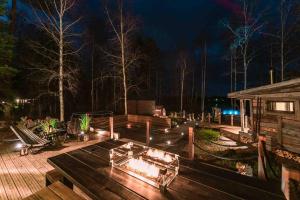 a wooden deck with a fire pit at night at Ihana paikka jossa ulkoporeallas sekä pihasauna in Loppi