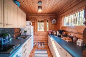 a kitchen with wooden walls and wooden counters at Ihana paikka jossa ulkoporeallas sekä pihasauna in Loppi