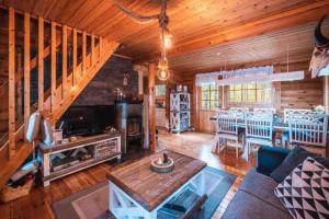 a living room with a couch and a dining room at Minivilla Peikonpesä ulkoporeallas & pihasauna in Loppi