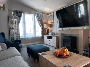 a living room with a table with a bowl of fruit at Beautiful 4 Berth Lodge With Free Wifi At Pakefield Holiday Park Ref 68019cr in Lowestoft