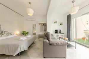 a bedroom with a bed and a couch and a table at Arco del Postigo in Seville