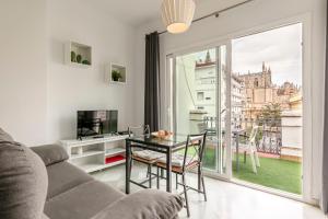 a living room with a table and a large window at Arco del Postigo in Seville