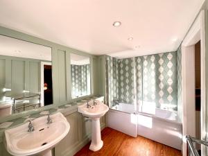 uma casa de banho com 2 lavatórios e uma banheira em Octon Cottages Luxury 1 and 2 Bedroom cottages 1 mile from Taunton centre em Taunton