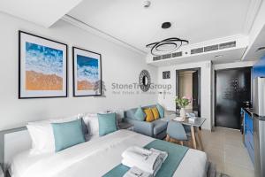 a bedroom with a bed and a living room at StoneTree - New Studio in JLT in Dubai