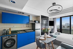 a kitchen and living room with blue cabinets at StoneTree - New Studio in JLT in Dubai