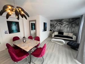 salon ze stołem i czerwonymi krzesłami w obiekcie Le Cannois, Appartement de star 3 chambres w Miluzie