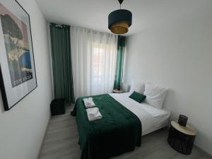 sypialnia z łóżkiem z zielonym kocem w obiekcie Le Cannois, Appartement de star 3 chambres w Miluzie