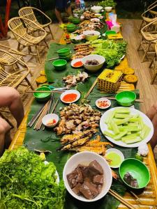 una larga mesa llena de comida y verduras. en ByVe Garden en Hanoi