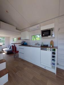 een keuken met witte kasten en een aanrecht bij Tiny House Paradies in Wustermark