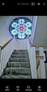 a staircase with a stained glass window above it at Peaceful Church Getaway in Middleton One Row