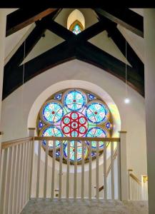 a stained glass window above a staircase in a church at Peaceful Church Getaway in Middleton One Row