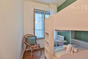um pequeno quarto com um beliche e uma cadeira em Appartement central, vue mer époustouflante. em Les Sables-dʼOlonne