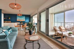 a living room with a blue couch and a table at Appartement central, vue mer époustouflante. in Les Sables-dʼOlonne