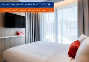 a hotel room with a bed and a large window at Holiday Inn Express Antwerp - City Centre, an IHG Hotel in Antwerp