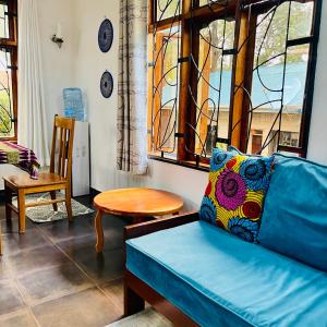 a living room with a blue couch and a table at Sophie Homestay in Moshi