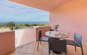 イーゾラ・ロッサにあるResidence with swimming-pool in Isola Rossa, just about 2 km from the beach La Marineddaのバルコニーにテーブルと椅子が置かれたダイニングルーム