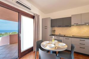 a kitchen and dining room with a table and chairs at ISA-Residence with swimming-pool in Isola Rossa, apartments with air conditioning and private outdoor area in Isola Rossa