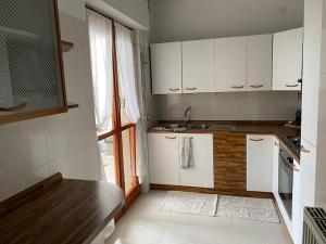 a kitchen with white cabinets and a sink at Lella's Home in Quartu SantʼElena +15 photos