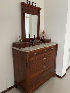 een houten dressoir met een spiegel erop bij Lella's Home in Quartu SantʼElena