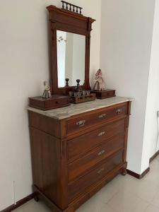 a wooden dresser with a mirror on top of it at Lella's Home in Quartu SantʼElena