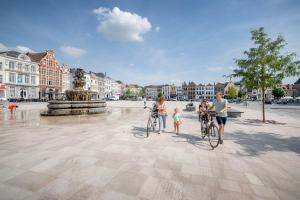 un grupo de personas de pie con bicicletas en una fuente en Leopold Hotel Oudenaarde, en Oudenaarde