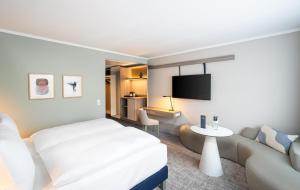 une chambre d'hôtel avec un lit et un canapé dans l'établissement voco Vienna Prater, an IHG Hotel, à Vienne