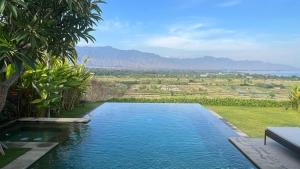a pool of water with a view of a field at Bula Villa in Umeanyar
