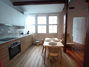 eine Küche mit einem Tisch mit Stühlen und einem Fenster in der Unterkunft VibesCoruña- Picavia 3 in A Coruña