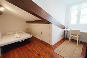 ein Schlafzimmer mit einem Bett und einem Stuhl im Dachgeschoss in der Unterkunft VibesCoruña- Picavia 3 in A Coruña