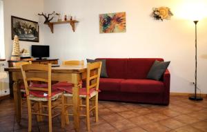 a living room with a table and a red couch at Chalet Abetone in Tuscany in Abetone