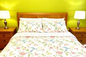 a bedroom with a bed with a floral bedspread and two lamps at Flat in Manchester, Ardwick in Manchester