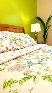a bed with a comforter with flowers on it at Flat in Manchester, Ardwick in Manchester
