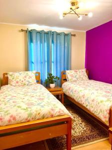 a room with two beds and a window with blue curtains at Flat in Manchester, Ardwick in Manchester