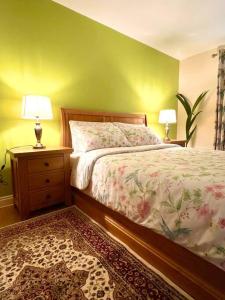 a bedroom with a bed with a green wall and two lamps at Flat in Manchester, Ardwick in Manchester