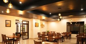 a dining room with tables and chairs and lights at Pine Hideout in Kathua