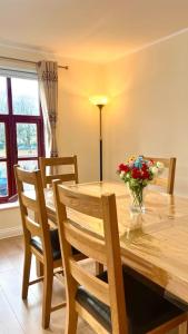 a dining room table with a vase of flowers on it at Flat in Manchester, Ardwick in Manchester