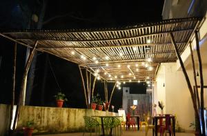 a patio with a table and chairs and lights at Pine Hideout in Kathua