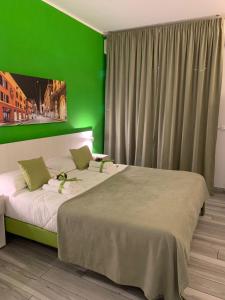 a bedroom with a large bed with a green wall at Bed End Breakfast Mary's Tower in Bologna