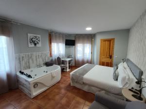 a hotel room with a bed and a bath tub at Biosfera Suites in Palomera