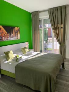 a green bedroom with a large bed in front of a window at Bed End Breakfast Mary's Tower in Bologna