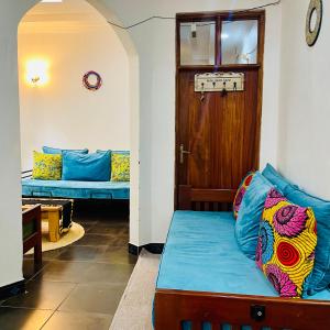 uma sala de estar com um sofá e uma porta em Sophie Homestay em Moshi