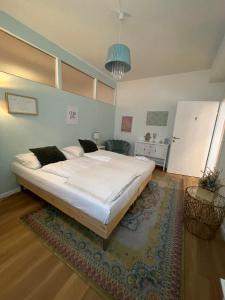 uma grande cama branca num quarto com um tapete em Der Salon Hostel em Viena