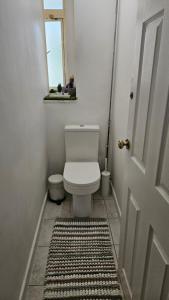 a bathroom with a toilet and a door with a rug at Spacious Two Bedroom Apartment in Battersea, Free Parking in London +19 photos