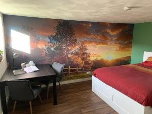 Un dormitorio con una cama y un escritorio con una pintura en Onze boerderij en Hoogersmilde