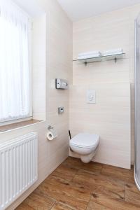 a white bathroom with a toilet and a window at Pension Nordkap in Bensersiel