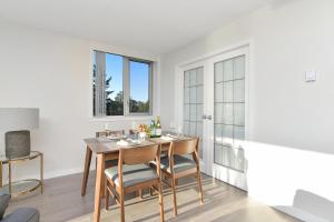 a dining room with a table and chairs and windows at Victoria West Harbourview in Victoria