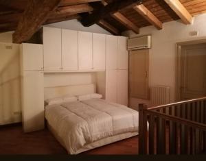 a bedroom with a large bed with white cabinets at De' Pepoli Rooms & Apartments in Bologna