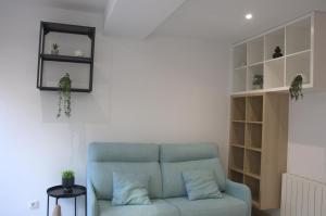 sala de estar con sofá azul y estante en Apartamentos Sudestada, en Logroño